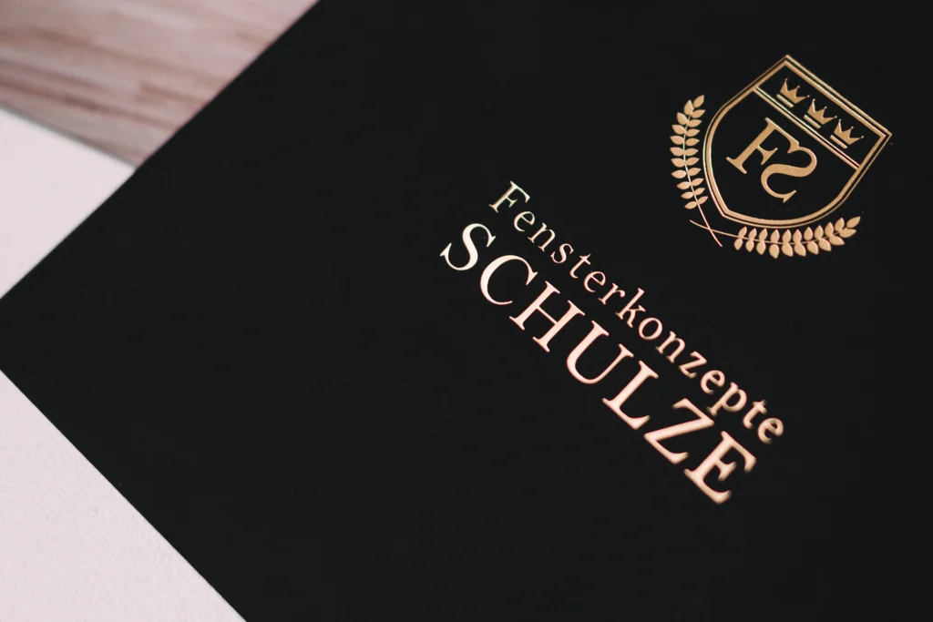Fensterbau-Schulze Eine Broschüre auf deren Titel in Heißfolie gold, das Logo von Fensterbau Schulze steht.