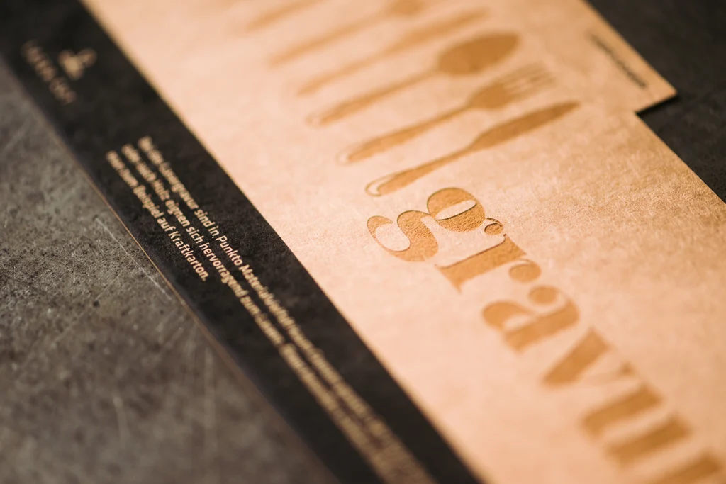 Laser-Gravur Ein Kraftkarton in den die Schrift „gravur“ eingraviert ist.